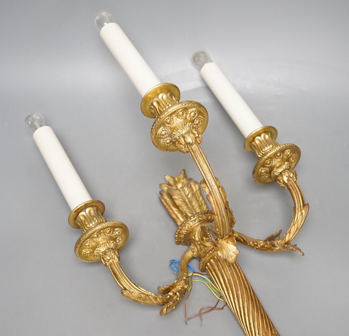 A Louis XVI style gilt bronze ‘bow and quiver’ three branch wall sconce - 59cm tall